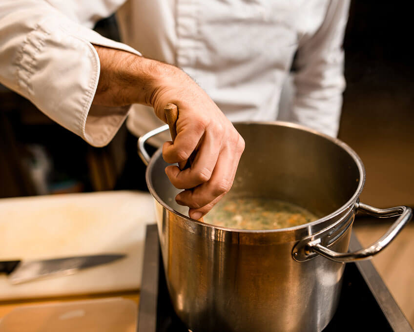 Chef stirring pot of soup