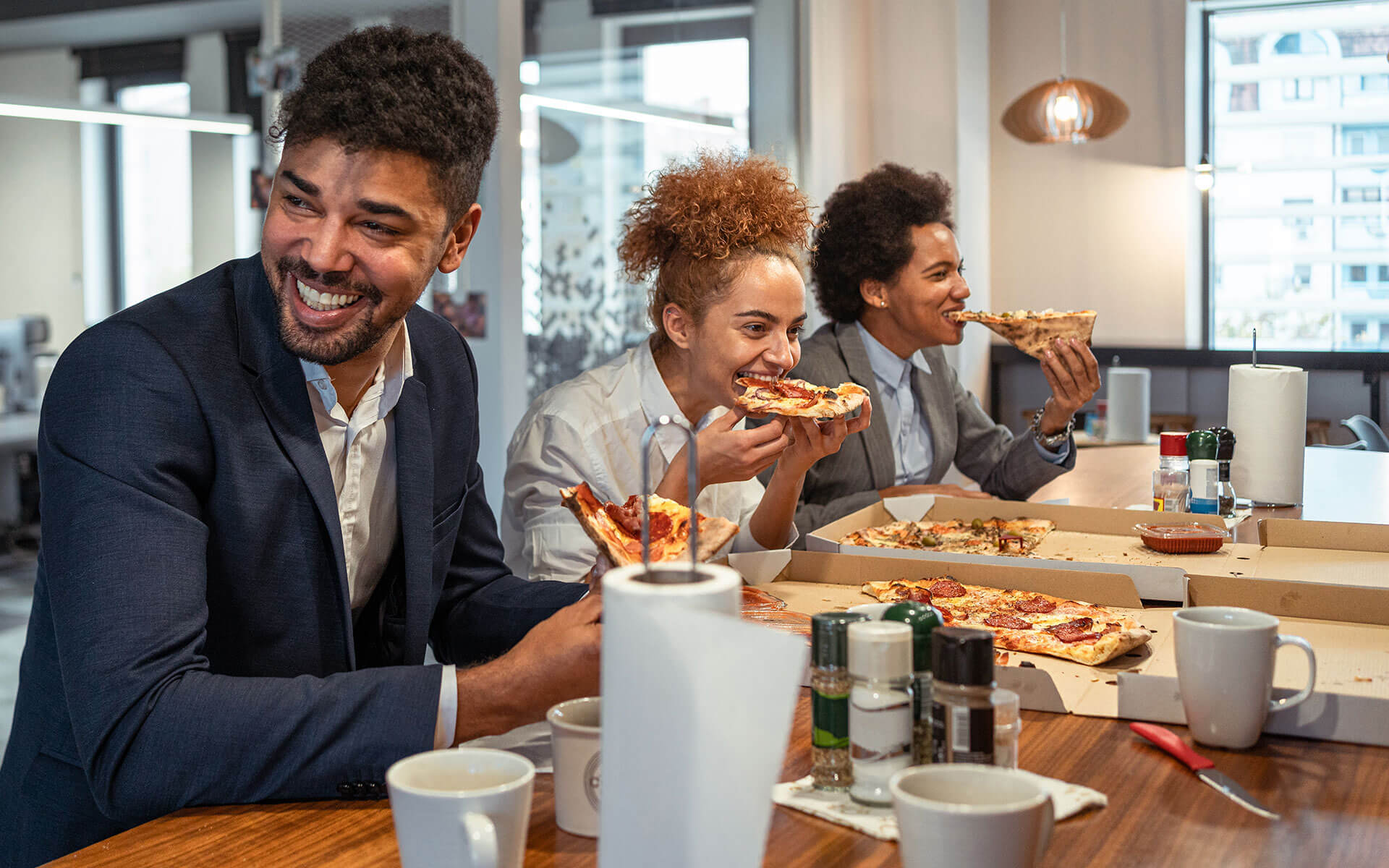 Group of business people eating pizza at restaurant